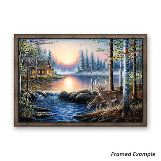 Framed canvas art showcasing a cabin by a lake, deer grazing, and a loon under a radiant sunrise